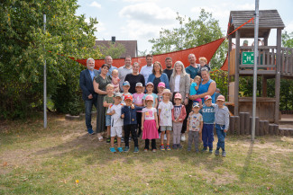Die Spenderinnen und Spender mit den Helfende und Kinder des Kindergartens vor dem neuen Segel.